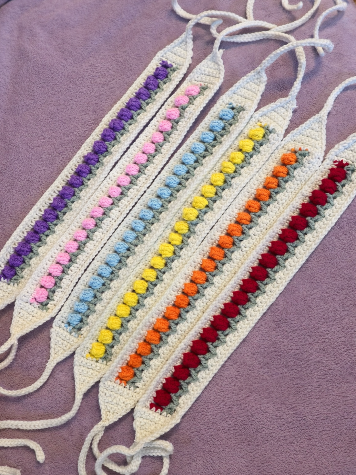 Colorful crocheted bookmarks on a purple fabric background