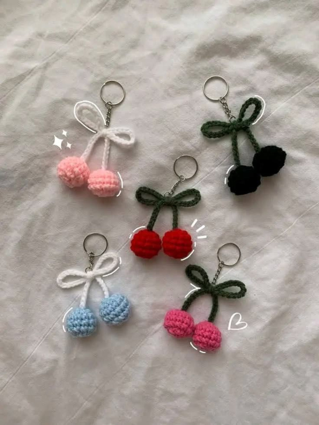 Set of colorful cherry-themed keychains on a light gray background