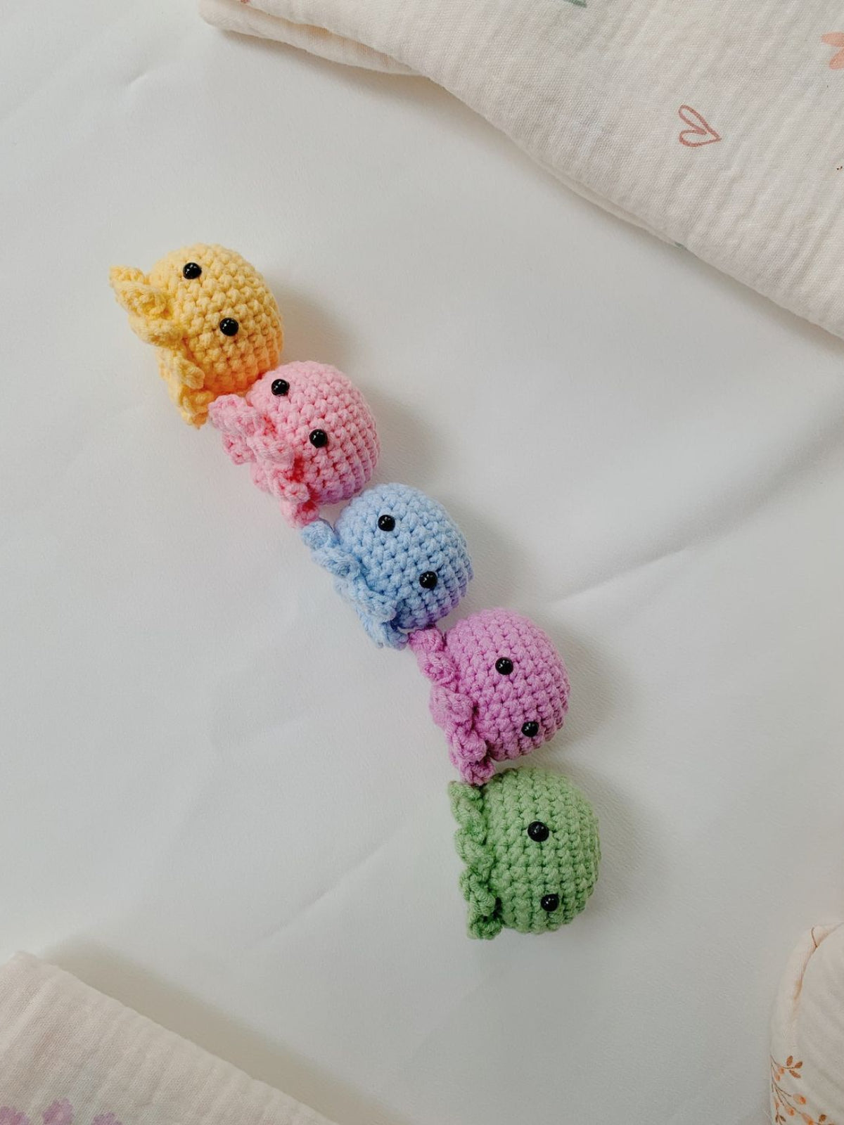 Colorful crocheted animal toys on a light surface