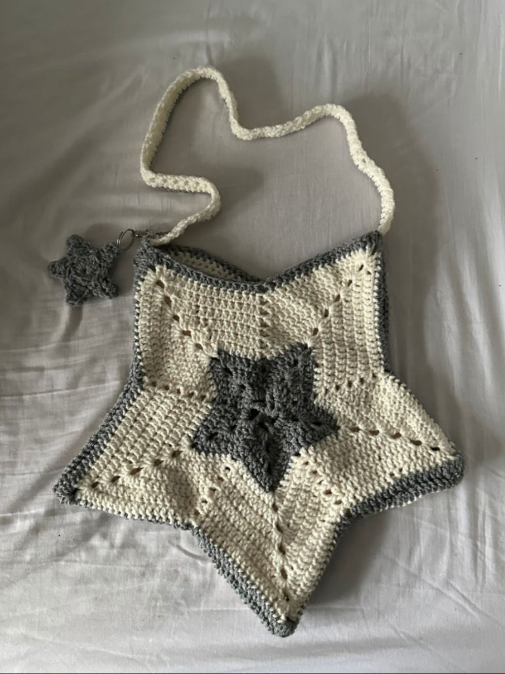 Crocheted bag with star design on a white fabric background
