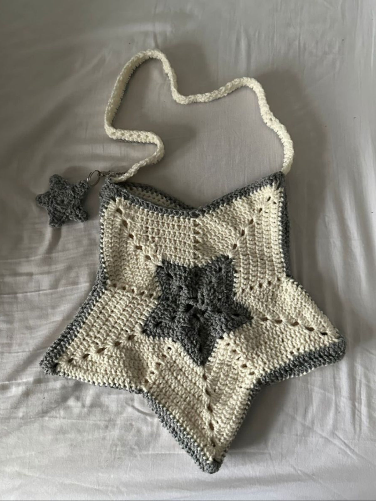 Crocheted bag with star design on a white fabric background