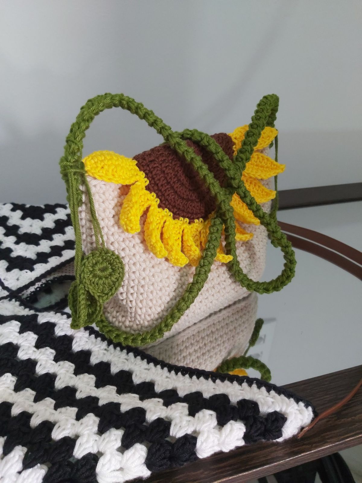 Handmade crochet bag with sunflower designs on a checkered surface
